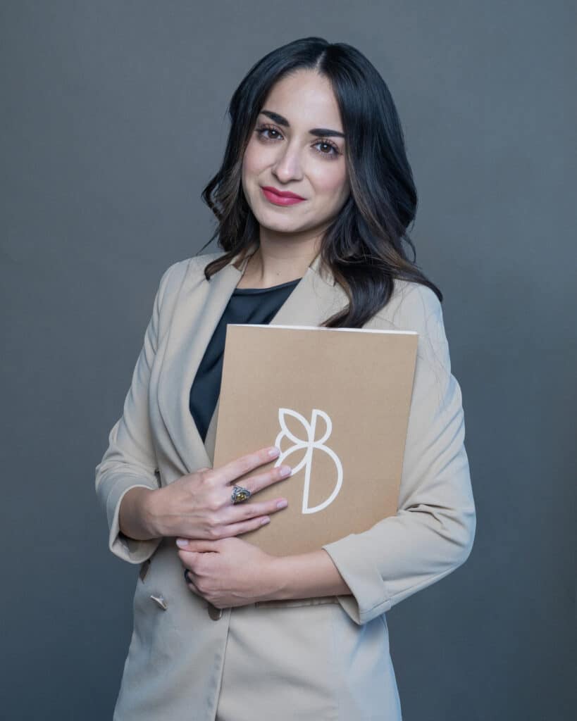 Immagine della segretaria della Butera Clinic, sorridente e accogliente, mentre tiene un documento, pronta a gestire le esigenze amministrative e a supportare i pazienti con professionalità.